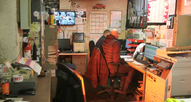 full distant view photo of mt gears sheffield garage office showing two office staff organising the gearboxes team and answering customer queries on the phone and emails too on the computer